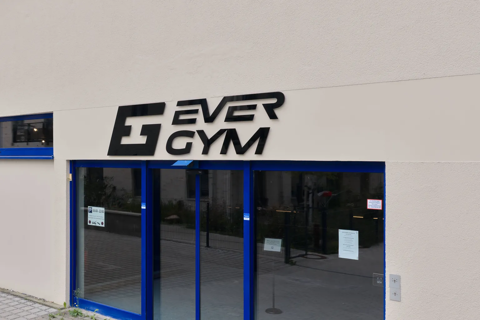 Der Eingang des EVERGYM Stahnsdorf mit dem Logo an der Fassade